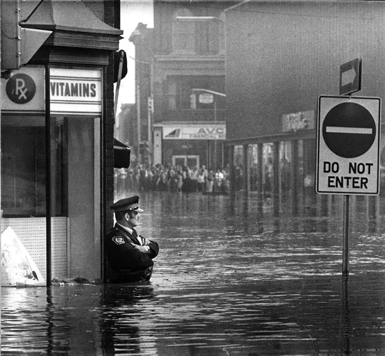 Const. Jack Shuttleworth in the 1974 flood in Galt, Cambridge; photograph credited to the KW Record